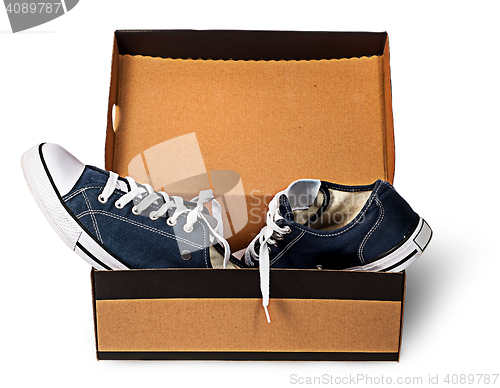 Image of Dark blue sports shoes abandoned in a cardboard box