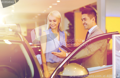 Image of happy woman with car dealer in auto show or salon