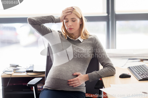 Image of pregnant businesswoman feeling sick at office work