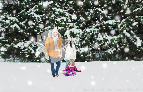 Image of happy family with sled walking in winter forest