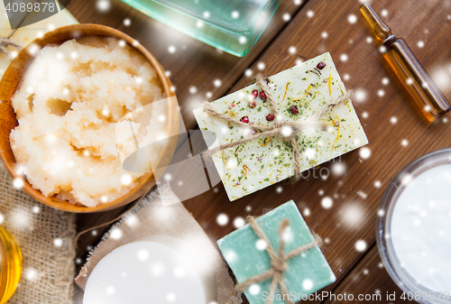 Image of body scrub and handmade soap bars on wood