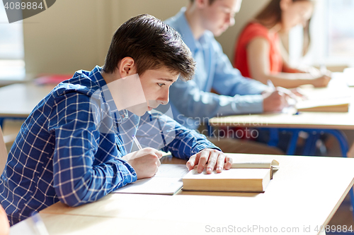 Image of group of students with books writing school test