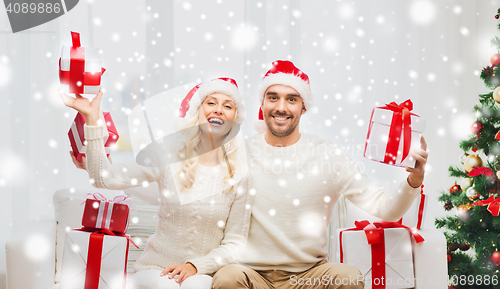 Image of happy couple at home with christmas gift boxes