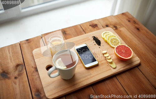 Image of smartphone with cup of lemon tea, honey and ginger