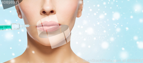 Image of close up of woman face and syringe over snow