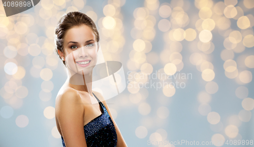 Image of smiling woman in evening dress over lights