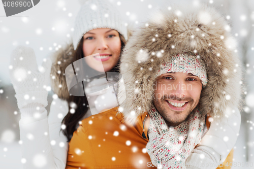 Image of happy couple having fun over winter background