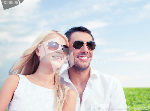 Image of happy couple in shades over natural background