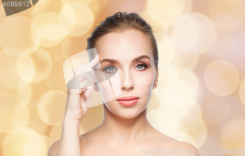 Image of beautiful woman pointing at her forehead