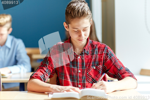 Image of group of students with books writing school test