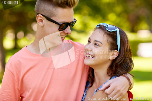 Image of happy teenage couple looking at each other in park