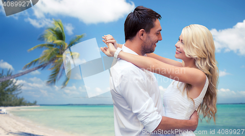Image of happy couple hugging over beach background