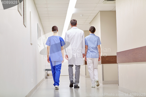 Image of group of medics or doctors walking along hospital