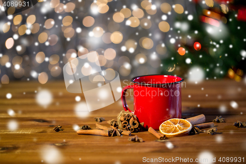 Image of tea cup with winter spices on wooden table