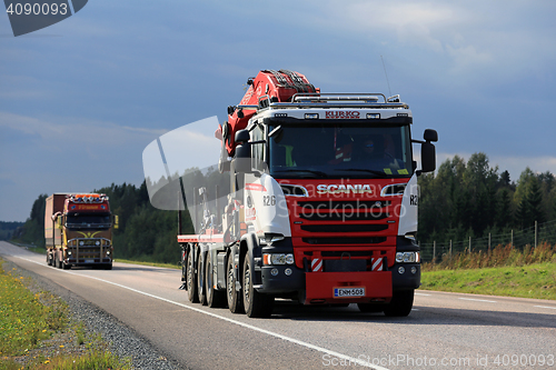 Image of Two Trucks Trucking Under Dark Sky