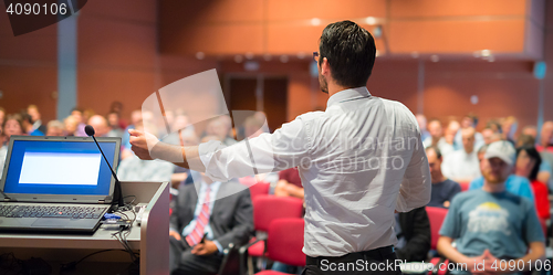 Image of Public speaker giving talk at Business Event.