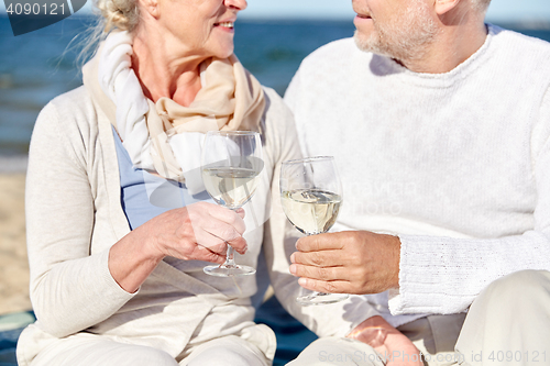 Image of happy senior couple drinking wine on summer beach