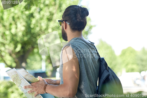 Image of close up of man with backpack and map in city