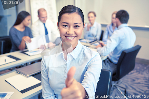 Image of group of smiling businesspeople meeting in office