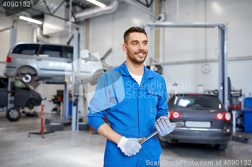 Image of auto mechanic or smith with wrench at car workshop