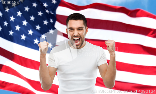 Image of angry man showing fists over american flag