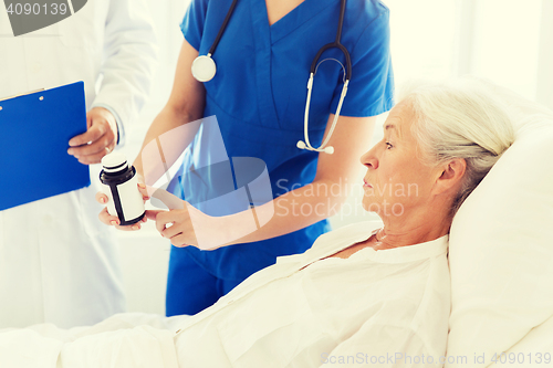 Image of doctor giving medicine to senior woman at hospital