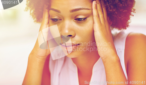 Image of close up of african young woman touching her head