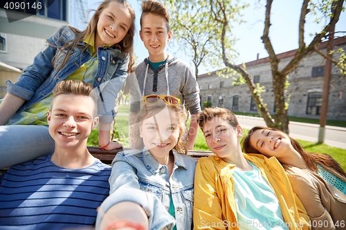 Image of happy teenage students or friends taking selfie