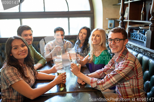 Image of happy friends drinking beer at bar or pub