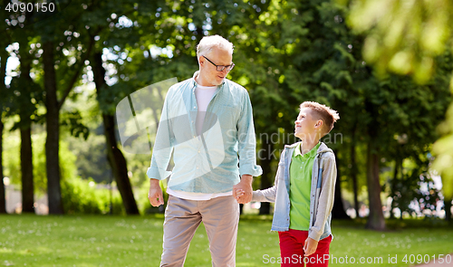 Image of grandfather and grandson walking at summer park