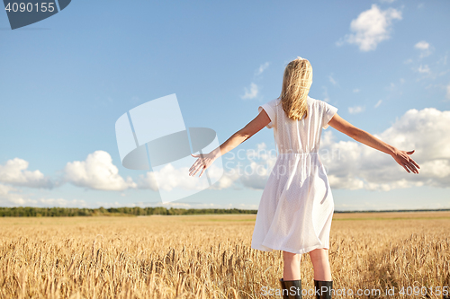 Image of happy young woman in white dress on cereal field