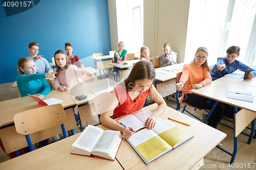 Image of students gossiping behind classmate back at school