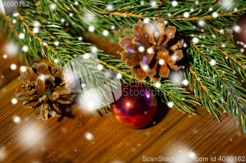 Image of fir branch with christmas ball and pinecones