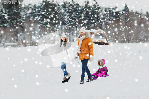 Image of happy family with sled walking in winter forest