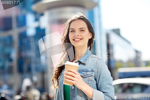 Image of happy young woman drinking coffee on city street