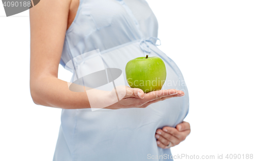 Image of close up of pregnant woman holding green apple