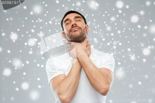 Image of young man choking himself over snow background