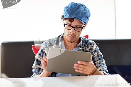 Image of man with tablet pc sitting at cafe table