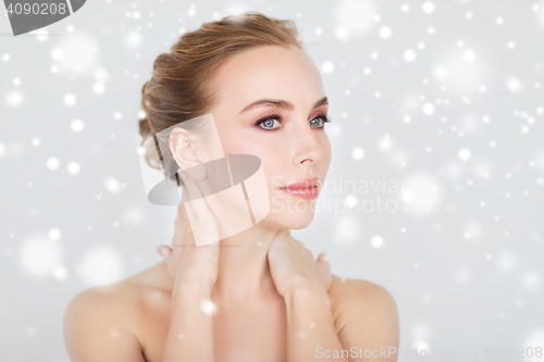 Image of beautiful young woman face and hands over snow