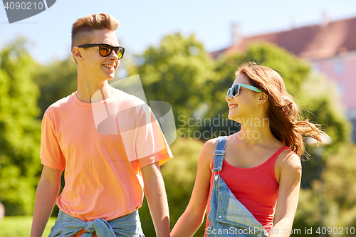 Image of happy teenage couple walking at summer park