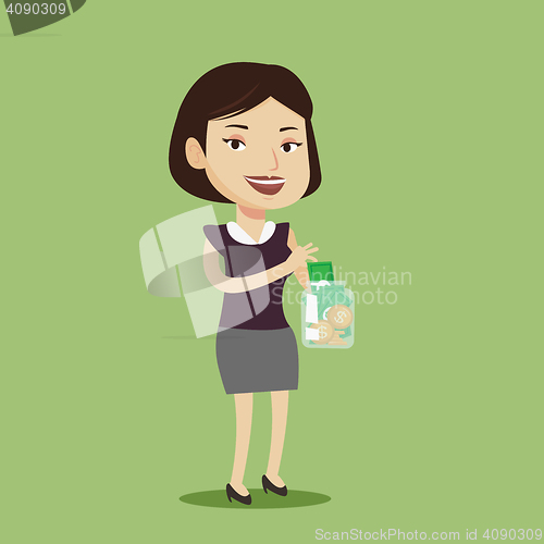 Image of Woman putting dollar money into glass jar.