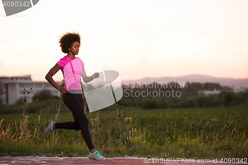 Image of a young African American woman jogging outdoors