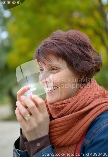 Image of Woman using throat spray