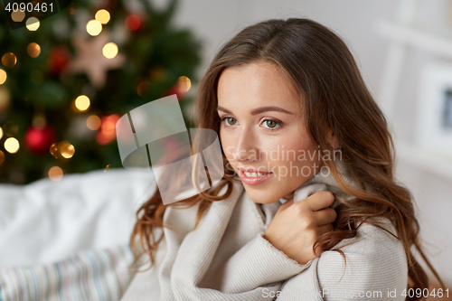 Image of happy young woman with plaid at home for christmas