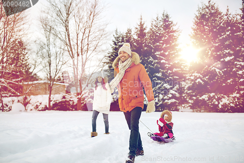 Image of happy family with sled walking in winter outdoors