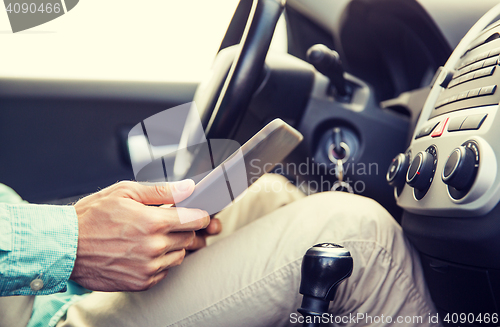 Image of close up of young man with tablet pc driving car