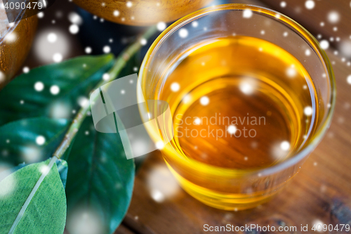 Image of close up of honey in glass with leaves on wood