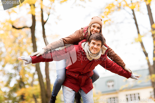 Image of happy young couple having fun in autumn park