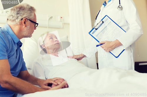 Image of senior woman and doctor with clipboard at hospital