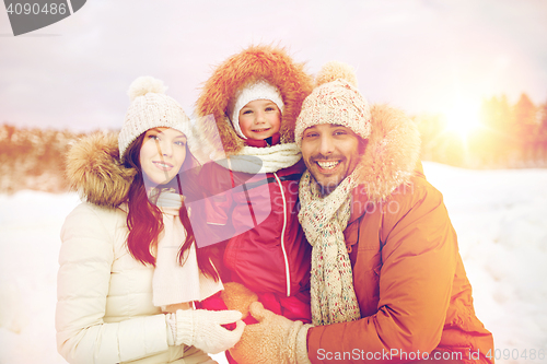 Image of happy family with child in winter clothes outdoors